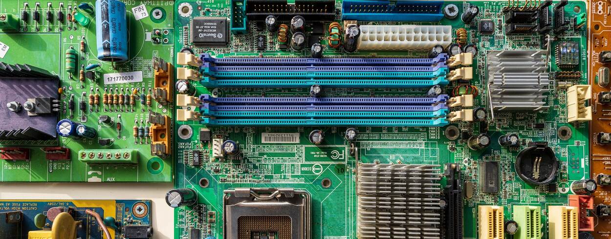 Een printplaat van een computer van bovenaf gezien met daarop transistors en andere verbindende elementen