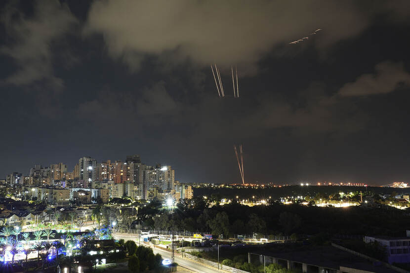 Luchtfoto in de nacht boven een stad met lichten van afweergeschut tijdens het conflict  in Israël en de Palestijnse gebieden