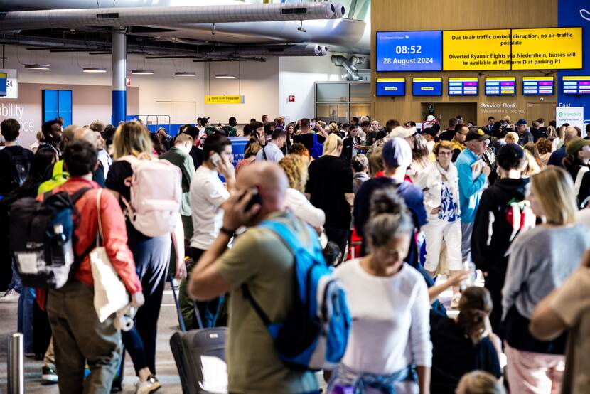 Reizigers op Eindhoven Airport, waar een grote storing het vliegverkeer heeft platgelegd.