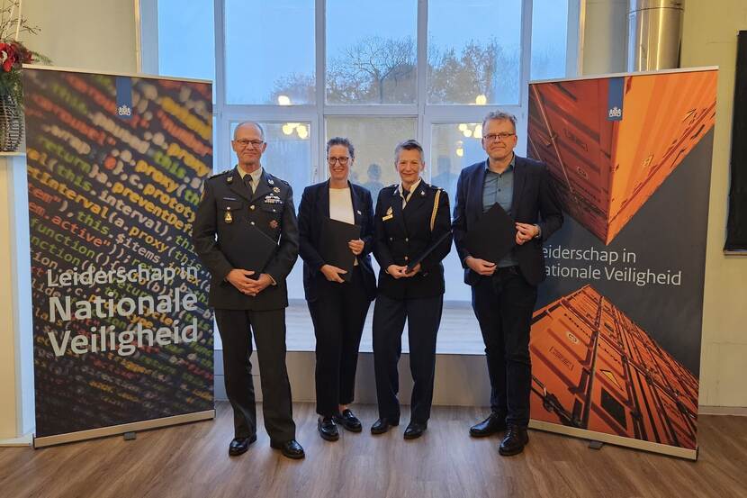 Vier vertegenwoordigers van de Academie Nationale Coördinator Terrorismebestrijding en Veiligheid (NCTV), de Nederlandse Defensie Academie, het Nederlands Instituut Publieke Veiligheid (NIPV) en de Politieacademie