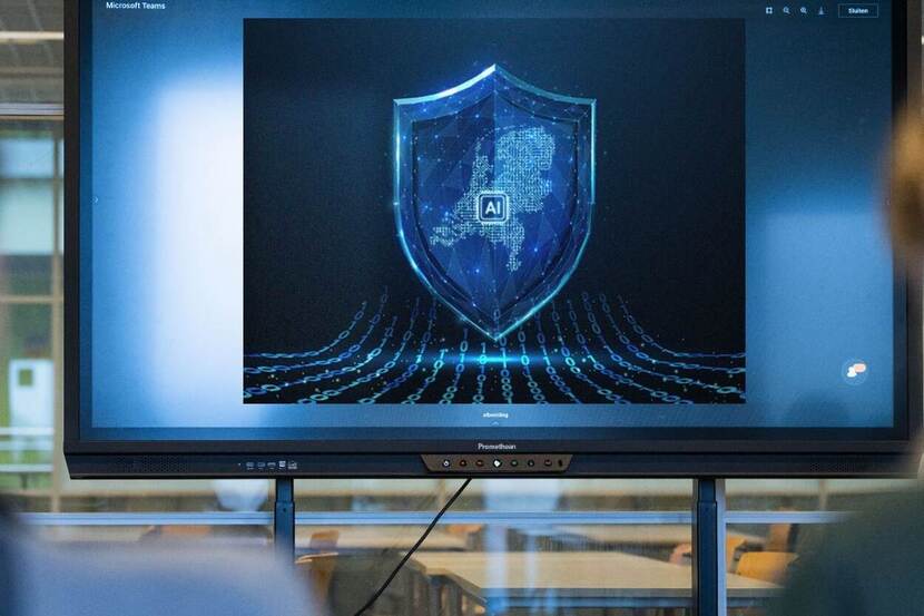 Een computerscherm met een schild in beeld. Op het schild zijn de contouren van Nederland zichtbaar en het woord AI.