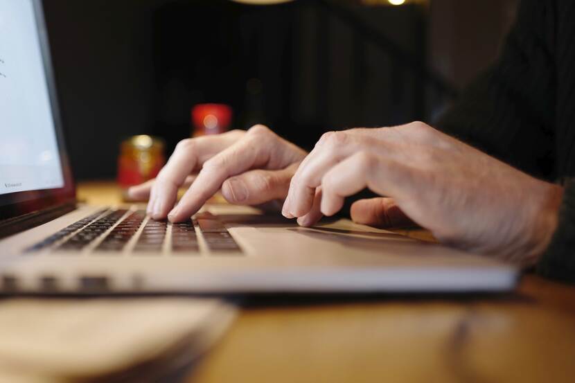 Handen op toetsenbord van laptop