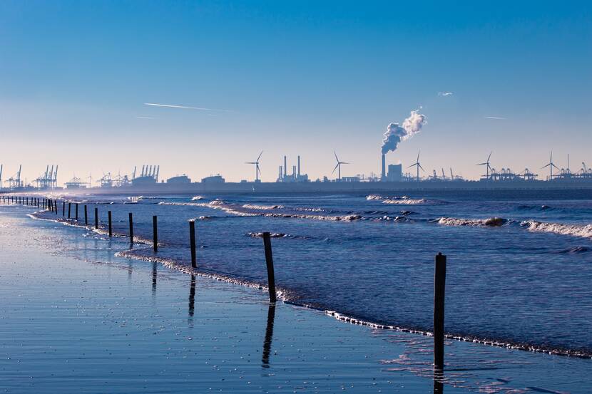 Weiland met op de achtergrond windmolens en fabrieken