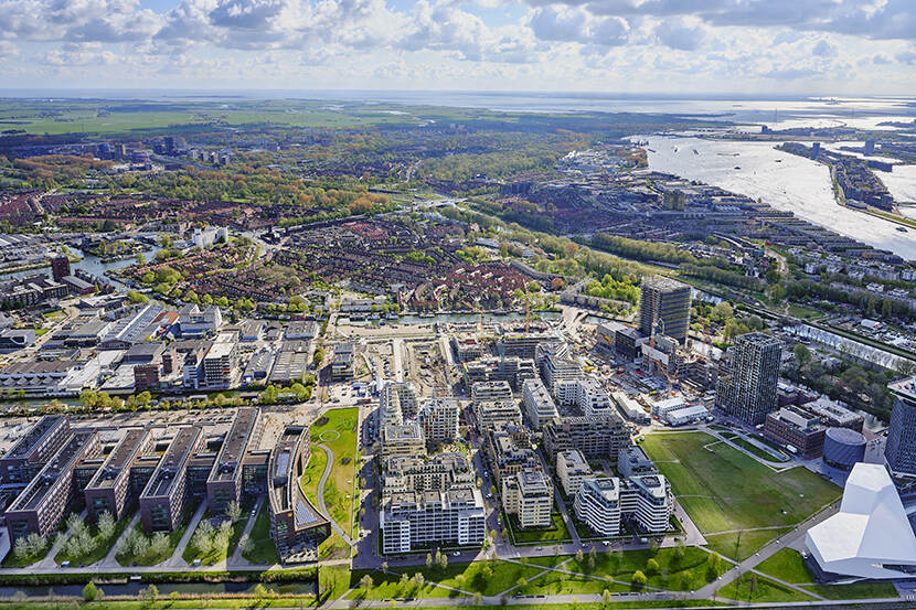 Luchtfoto van een staf met flats, huizen, industrie en rivier