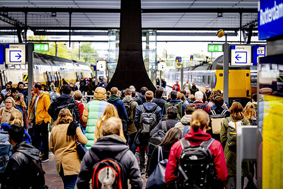 Veel mensen op het perron en in stappend in de trein